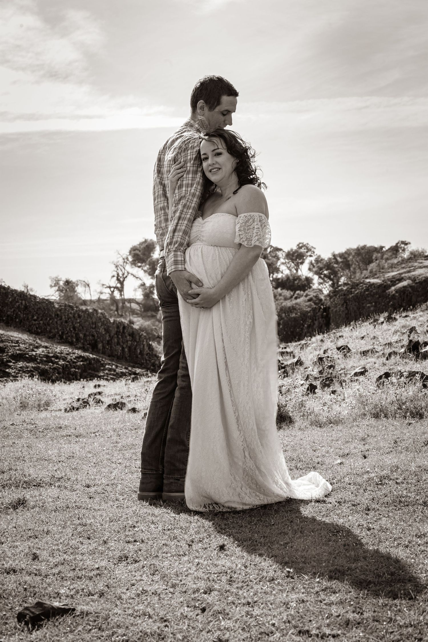 black & white image of a couple outside posing for maternity photos