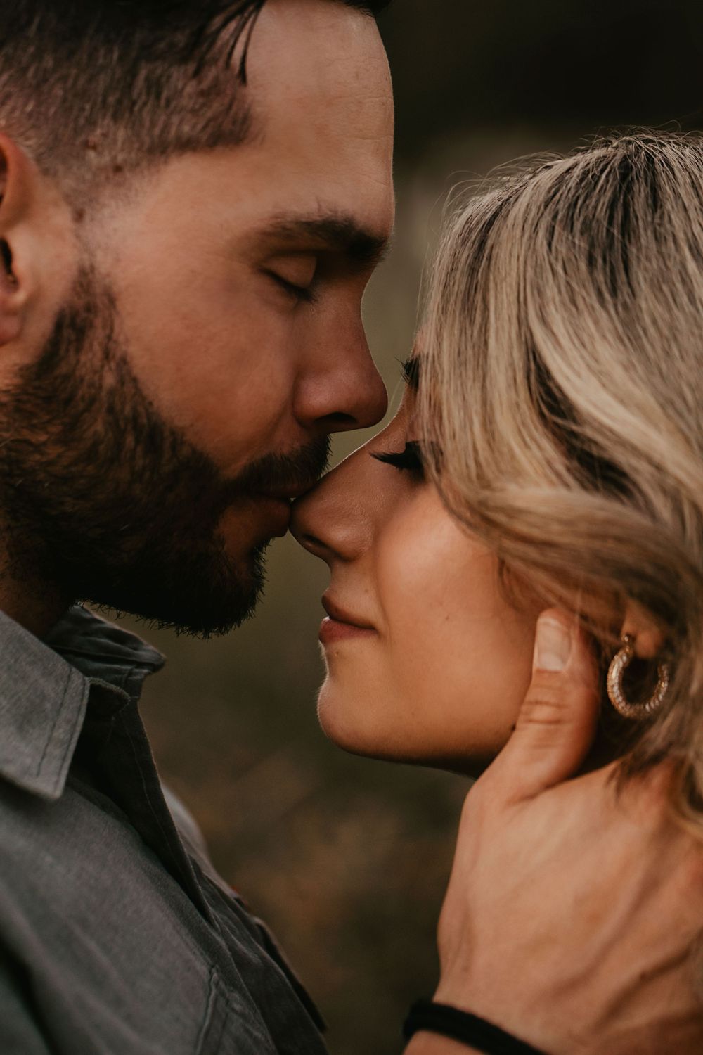 Intimate close-up portrait of a couple sharing a tender moment at sunset.