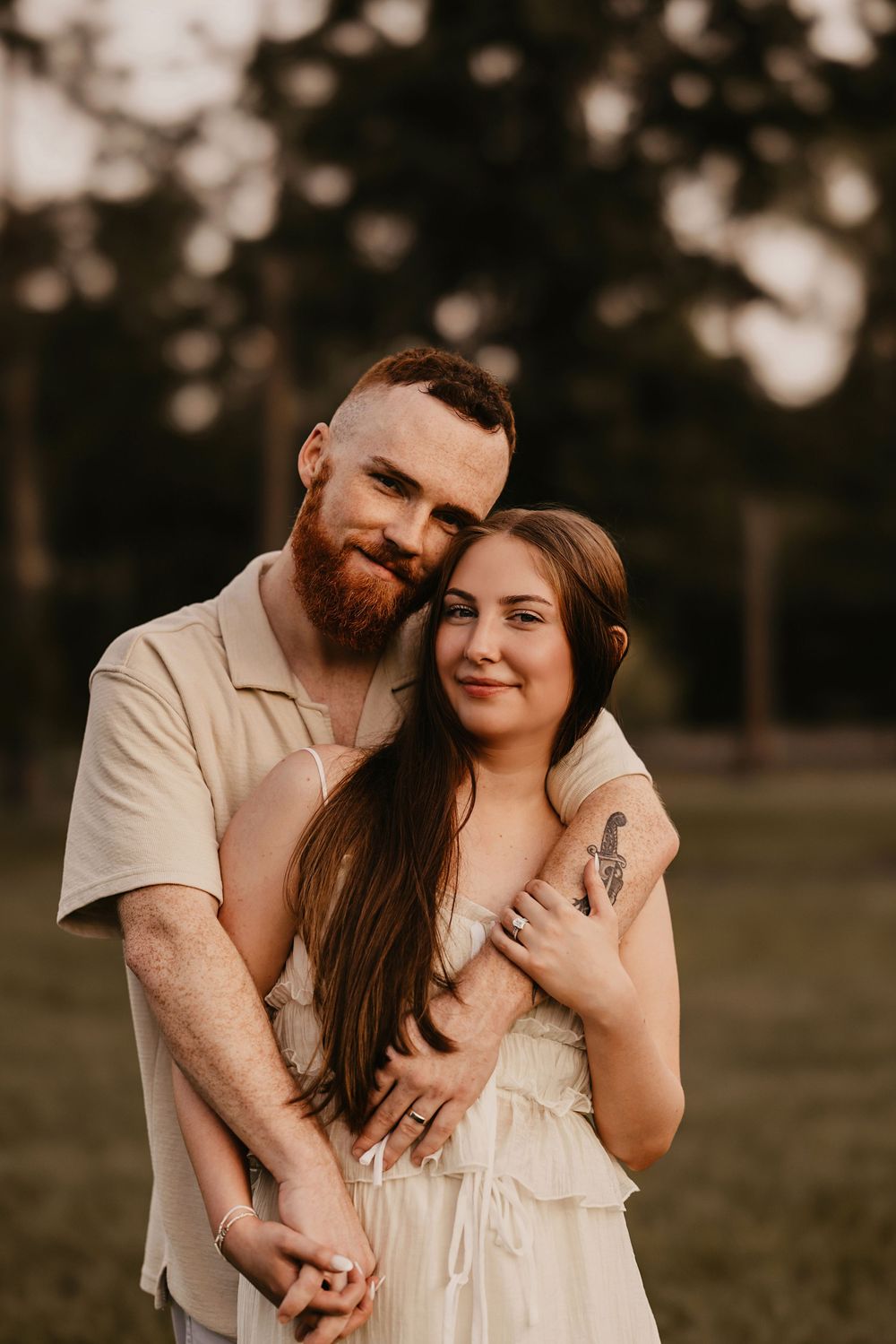 A couple shares tender moments in a romantic outdoor photoshoot at sunset with warm lighting and natural scenery.