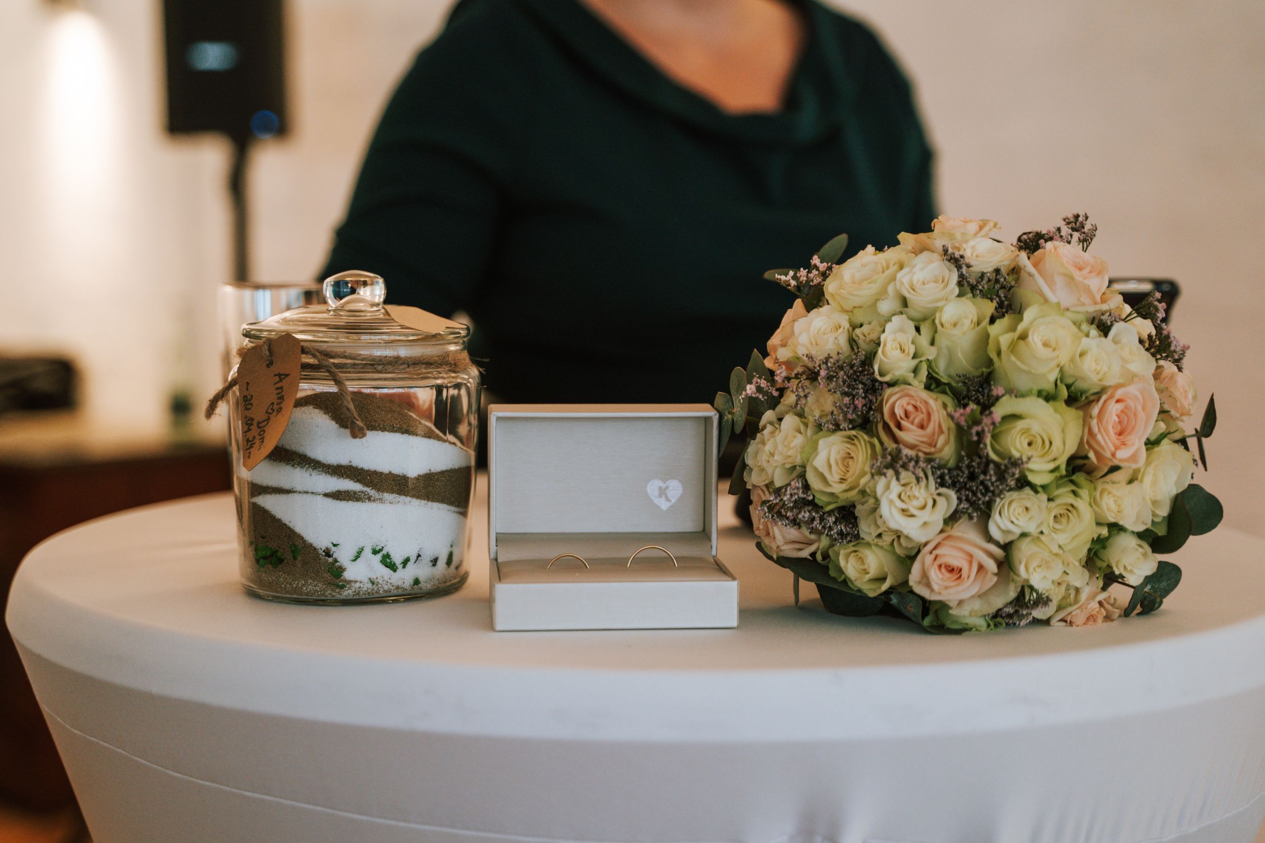 Elegant floral arrangements and wedding decor details on white tables.