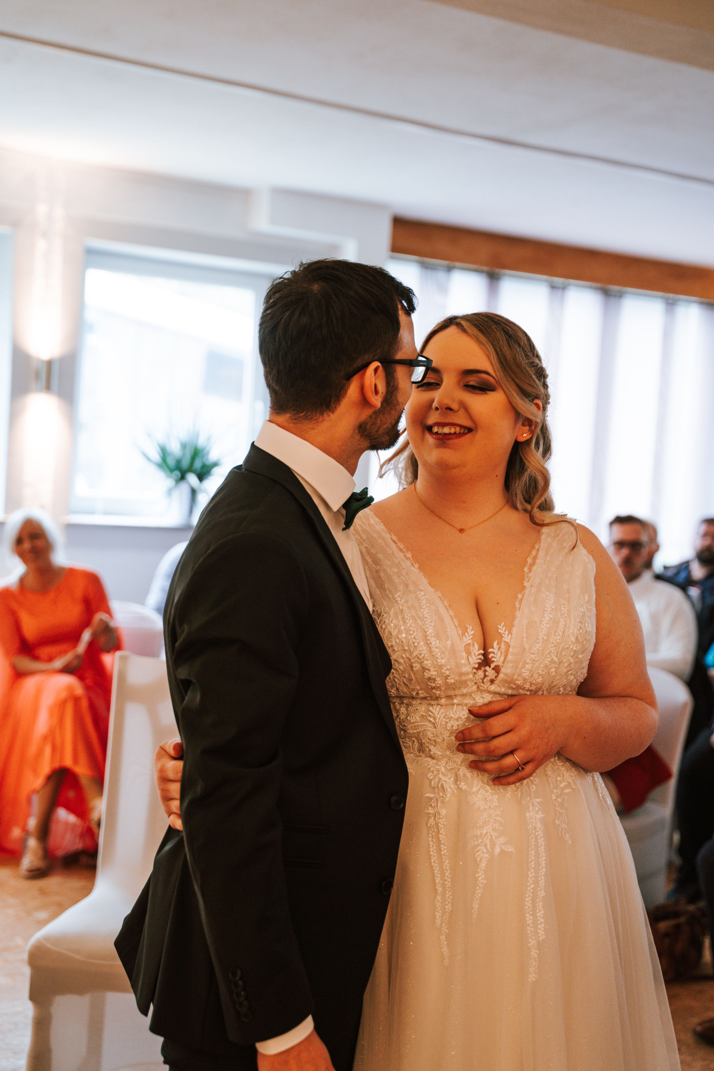 Joyful moments shared during wedding reception in a bright, airy venue.