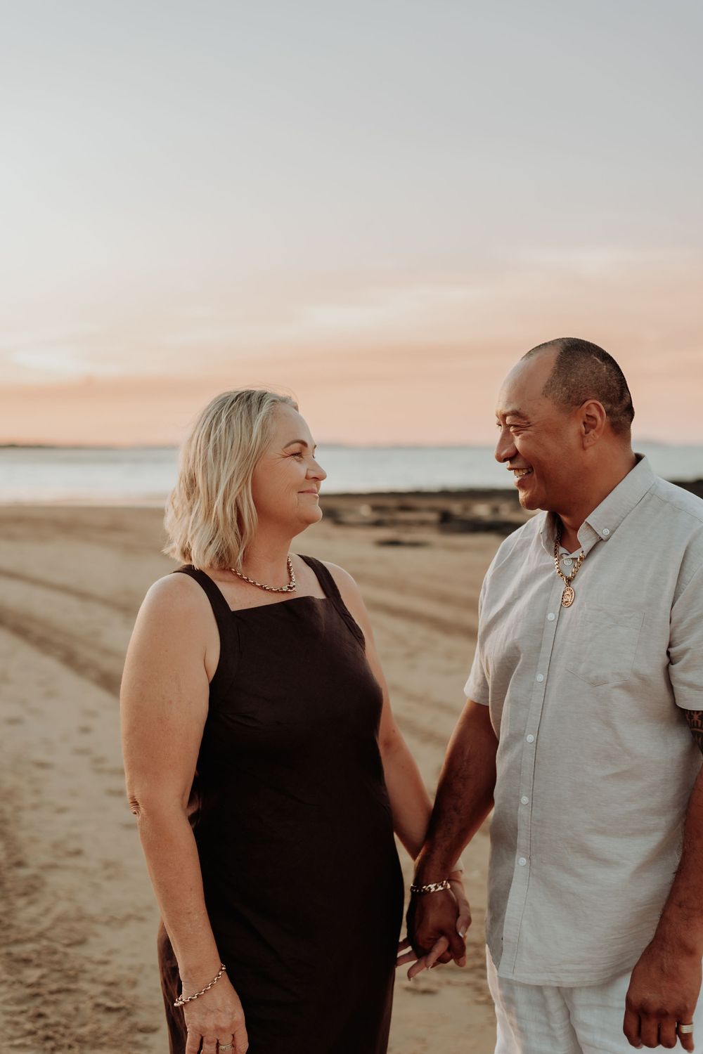 Romantic couple sharing a joyful moment on the tannum sands beach at sunset.