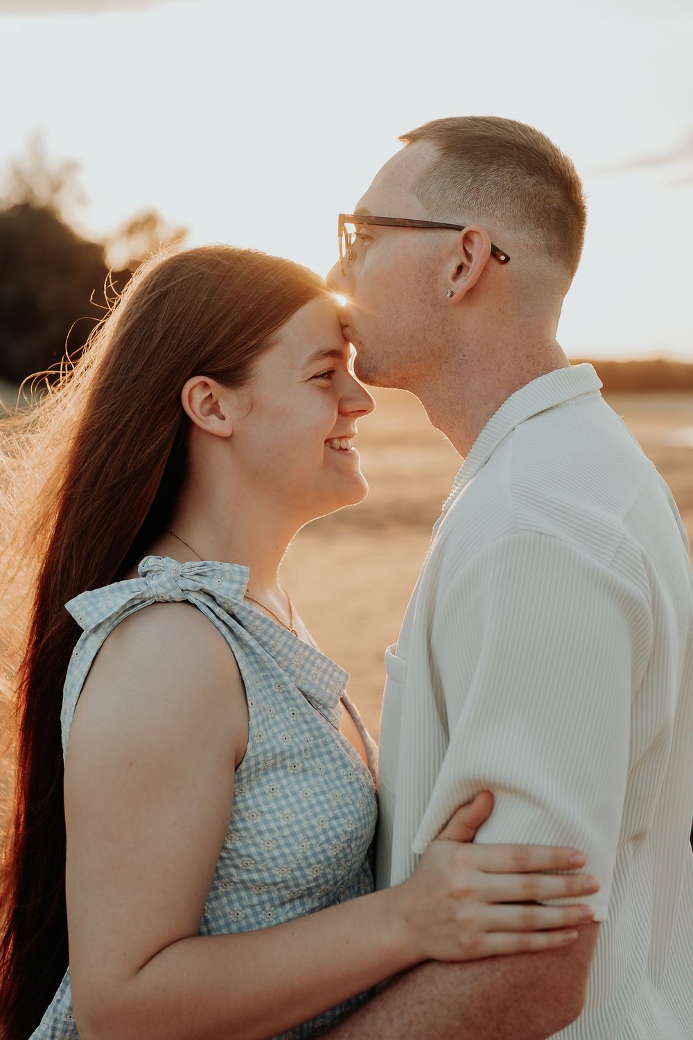Intimate couple portrait with sunlit glow during golden hour at gladstone beach.