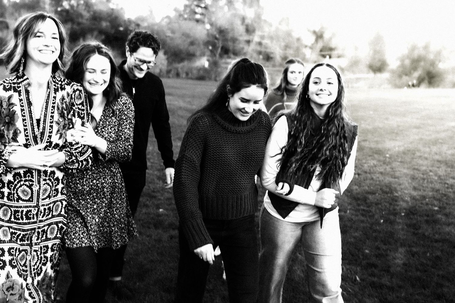 A series of black and white photos showing people posing together outdoors in a casual setting.