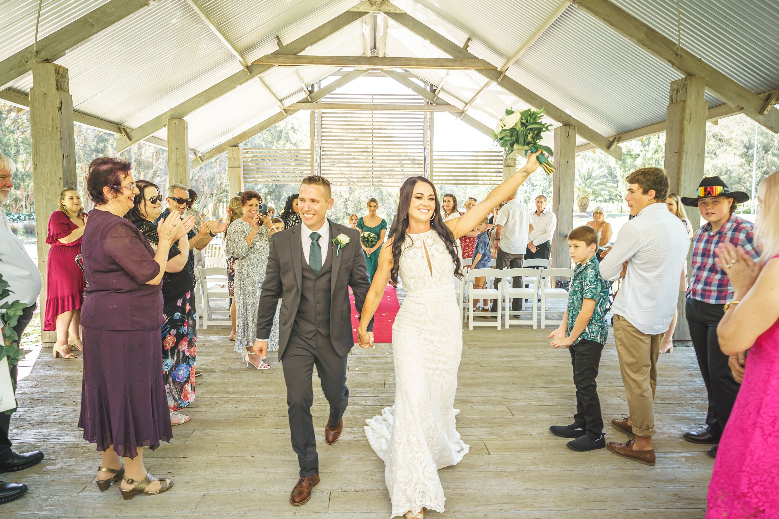 Guests celebrating in rustic indoor venue with vaulted ceiling.