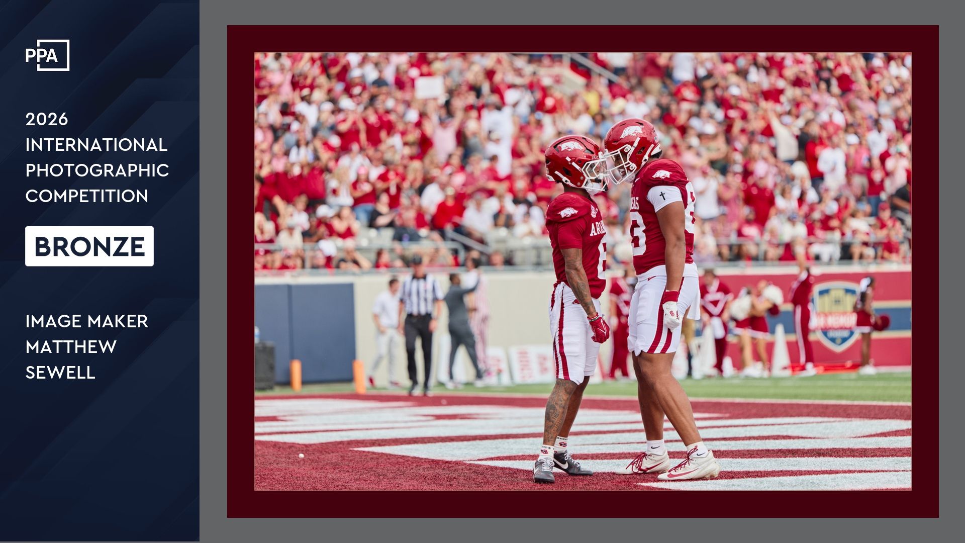 Two football players celebrate on a red-turf field, winning a 2026 PPA International Photographic Competition Bronze award.