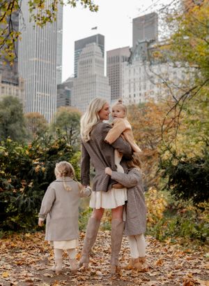 Family moment captured in Central Park during fall with skyscrapers in background.