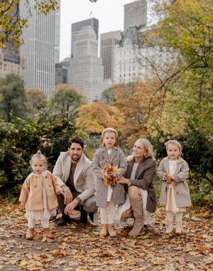 Group portrait in Central Park during fall with Manhattan skyline in background.