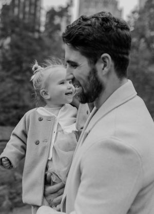 Tender moment captured in black and white between adult and child in matching coats.
