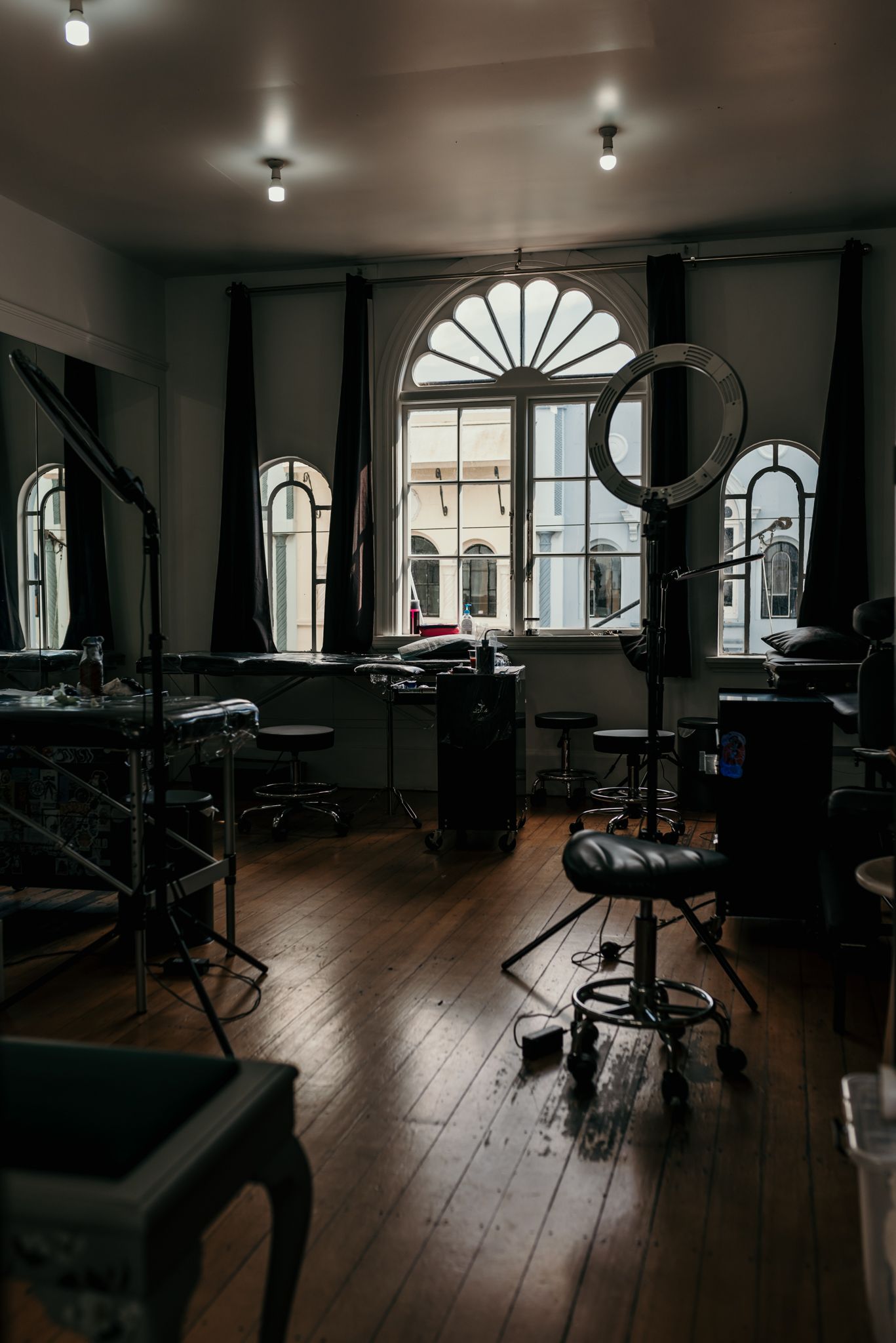 Elegant tattoo studio interior with arched windows and hardwood floors based in Christchurch.
