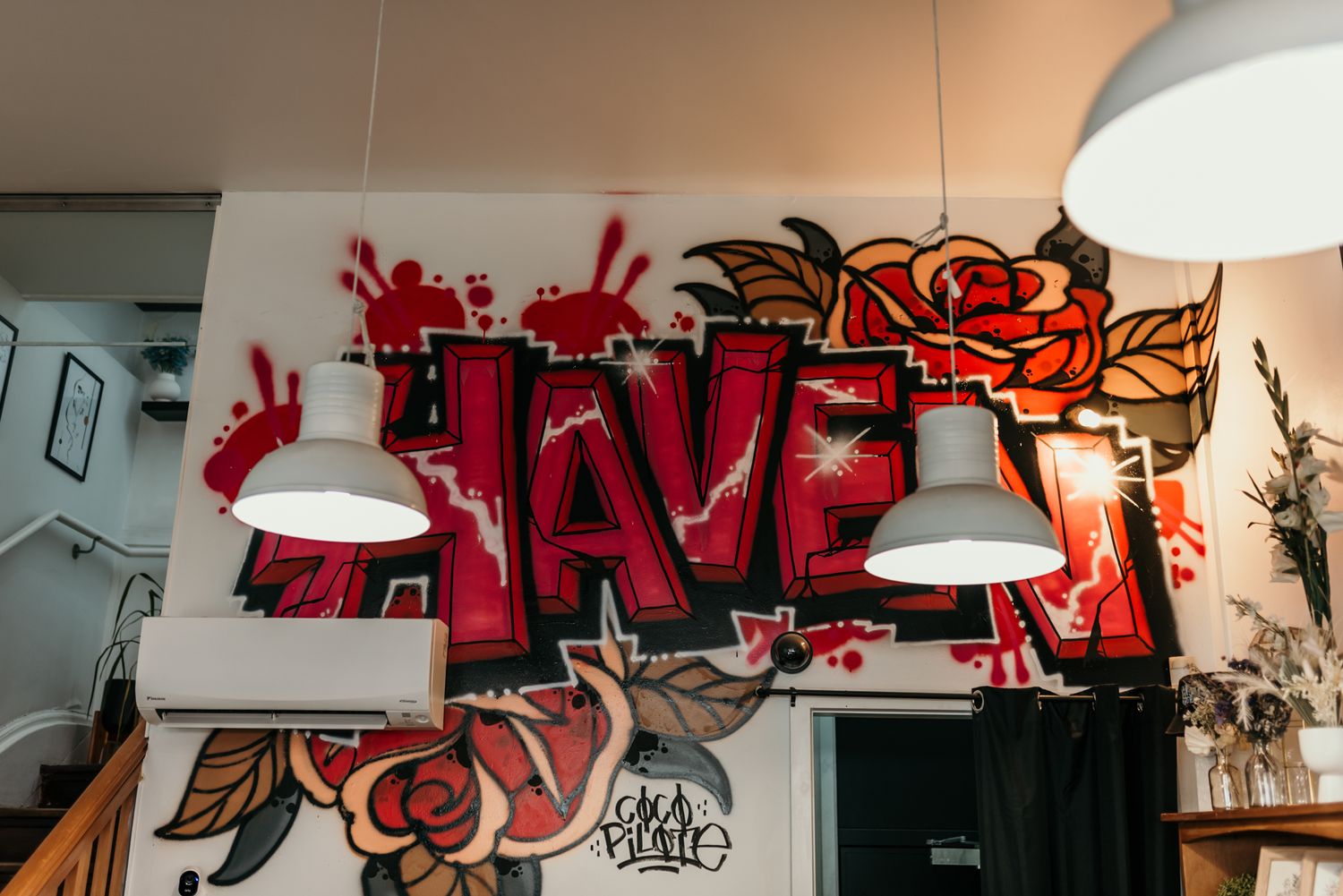 Urban graffiti art spelling 'Haven' in red with decorative pendant lights. in Christchurch.