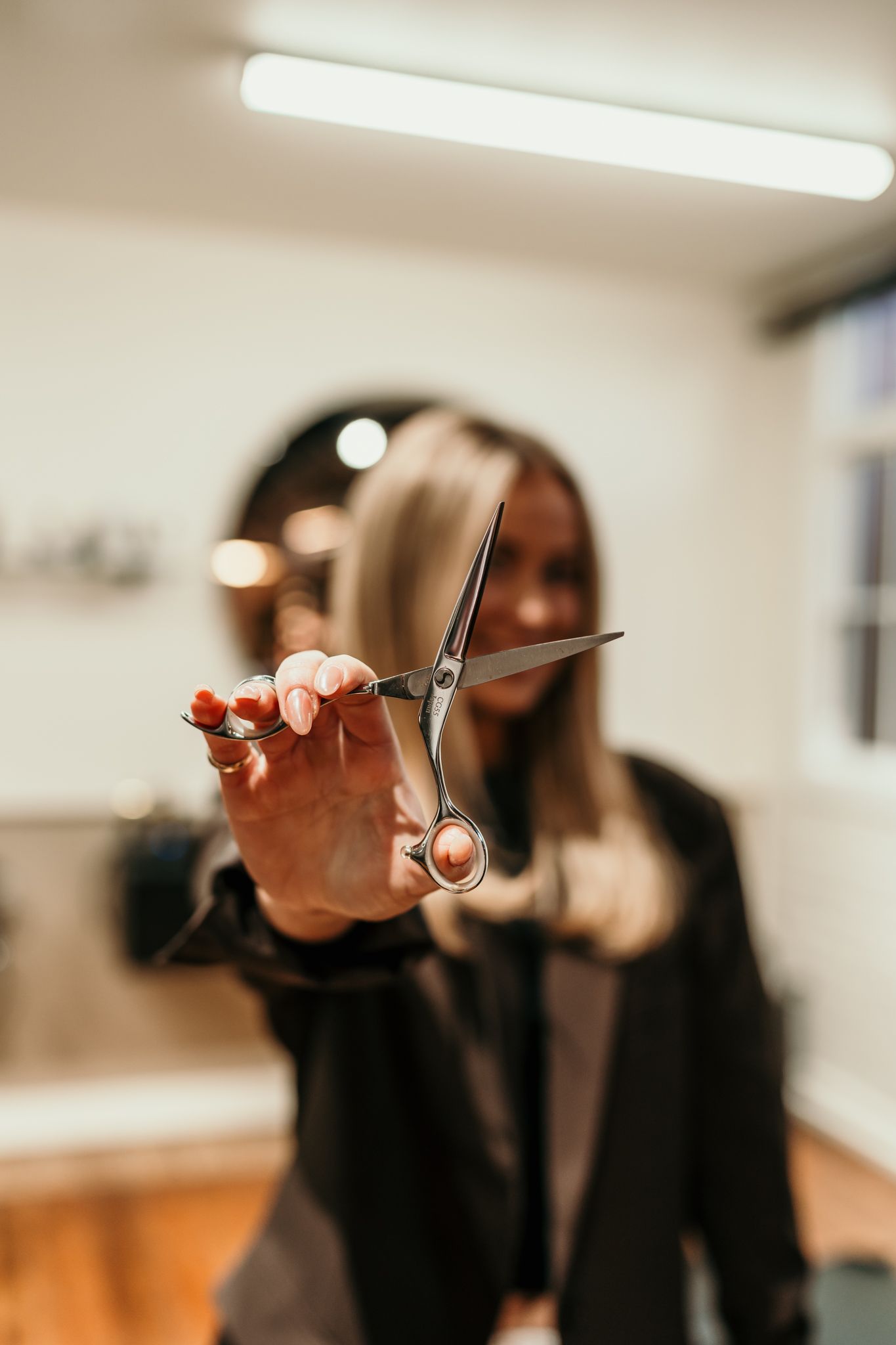 Cropped sequence of four photos showing hands holding scissors being raised against a blurred office background.