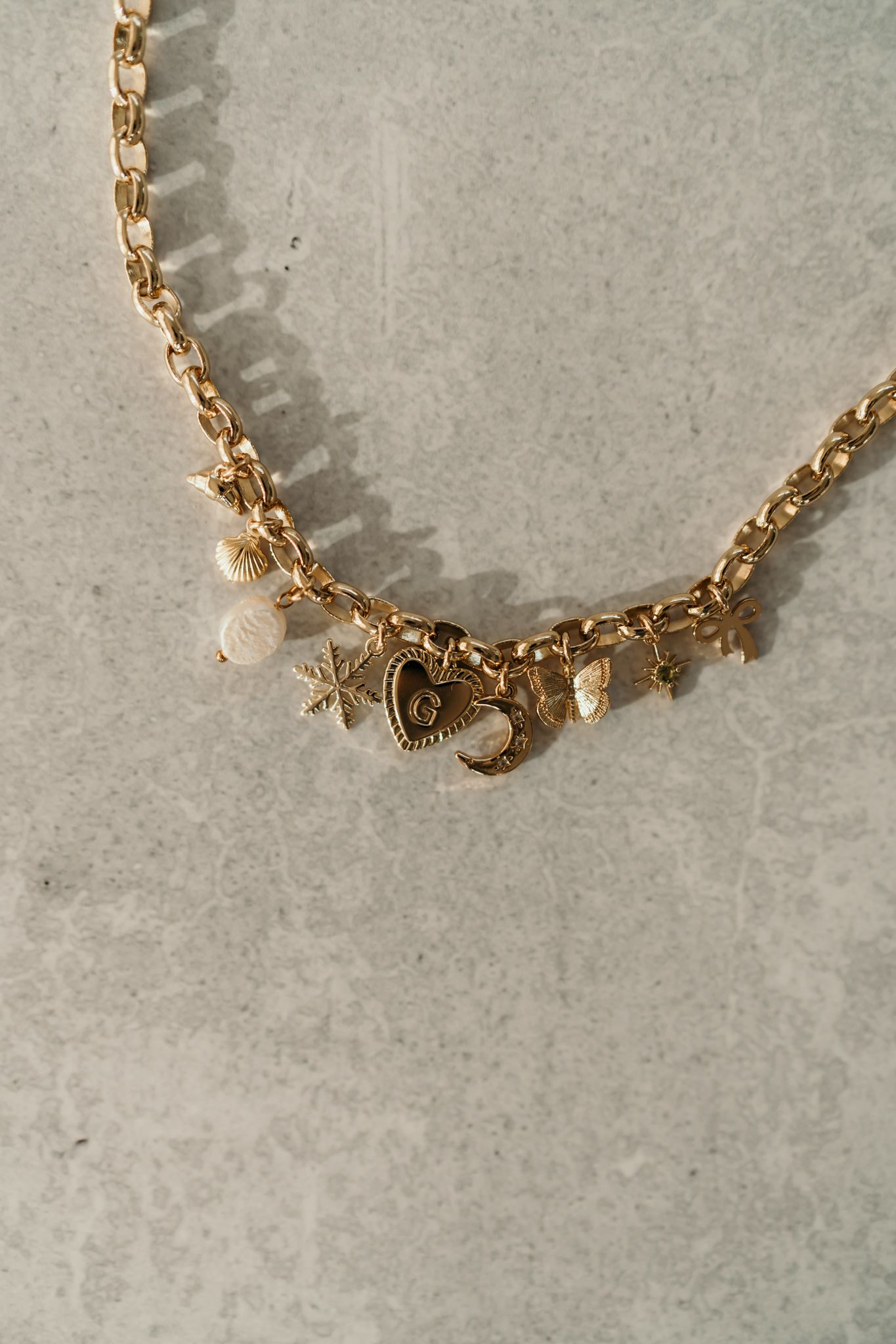 Gold chain necklace with toggle clasp captured in a sequence of progressive closeup detail shots on gray background.