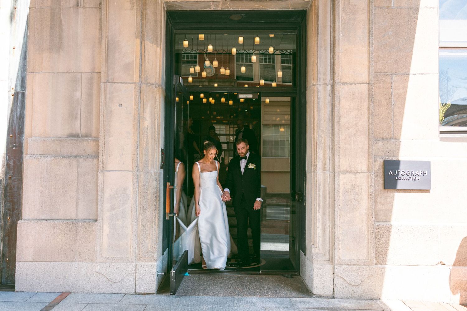 Wedding couple shares an intimate moment on a covered porch with white columns.