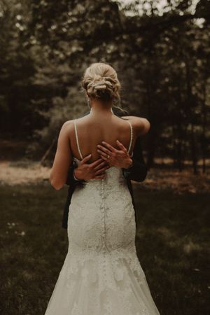 Back view of a bride in a lace wedding dress with her hair elegantly styled in an updo.