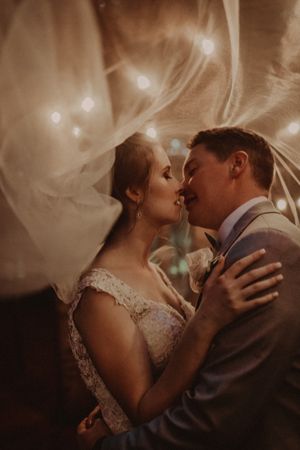 Romantic wedding portrait with flowing veil and soft sepia tones.