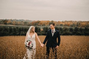 A romantic autumn wedding portrait in a golden wheat field at sunset.