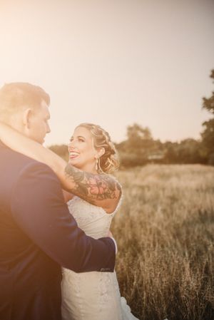 A sunset wedding portrait of a couple embracing in a golden field.