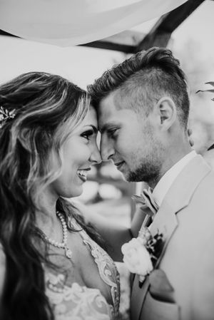 Black and white close-up wedding portrait under flowing veil.
