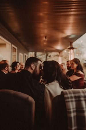 Intimate moment captured in warm-lit indoor setting.