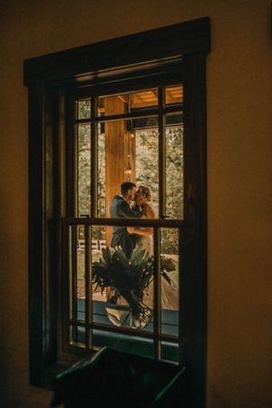 Silhouette of couple framed in window with romantic sunset lighting.