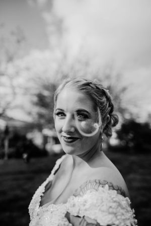 A black and white portrait captures a joyful expression and intricate bridal details.