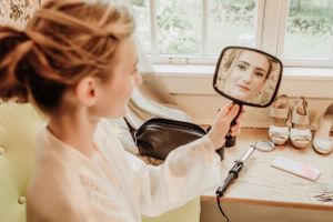 Wedding day preparation scene with mirror reflection and bridal accessories on vanity.