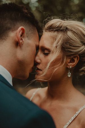 An intimate close-up wedding portrait capturing a tender moment between newlyweds.