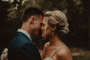 An intimate close-up portrait of a couple sharing a tender moment at their wedding.