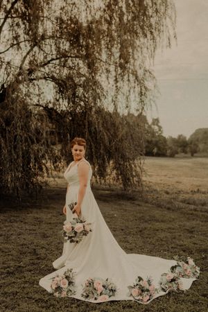 Classic bridal portrait under a weeping willow tree with floral dress details.