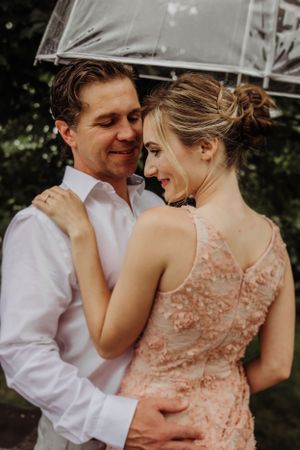 An intimate engagement photo of a couple sharing a tender moment outdoors.