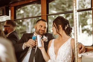 Couple sharing drinks and laughter during wedding reception celebrations.