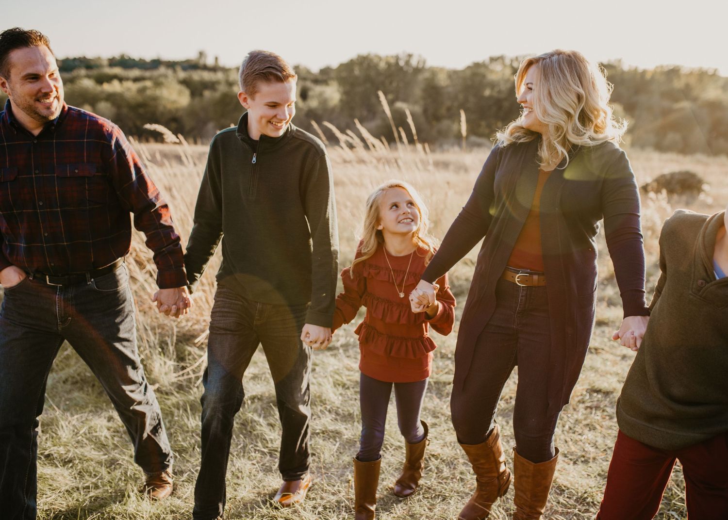 "Picture of happy family walking hand in hand at Sunset."