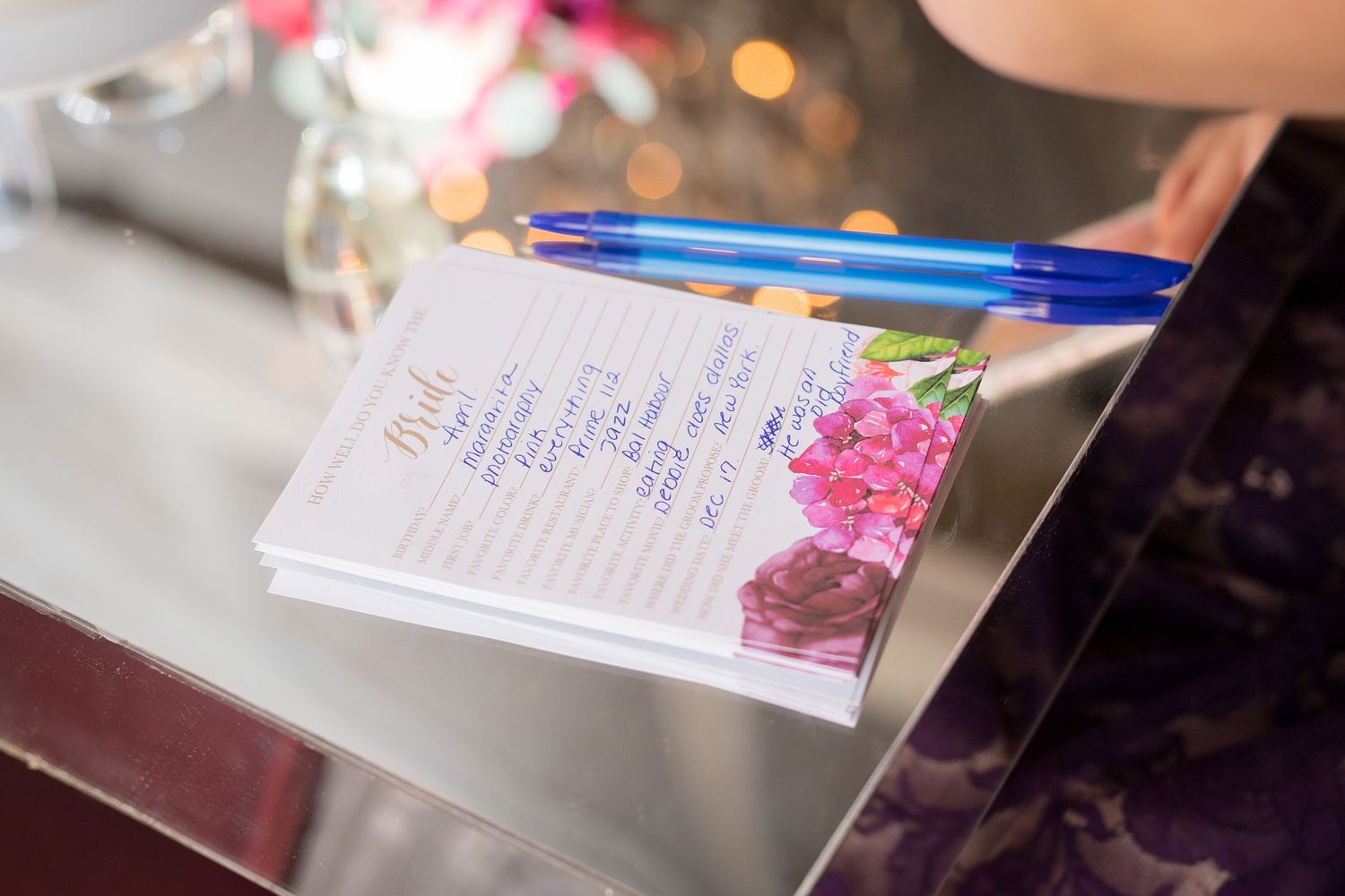 Wedding planning notebook with pink flower detail on reflective surface.
