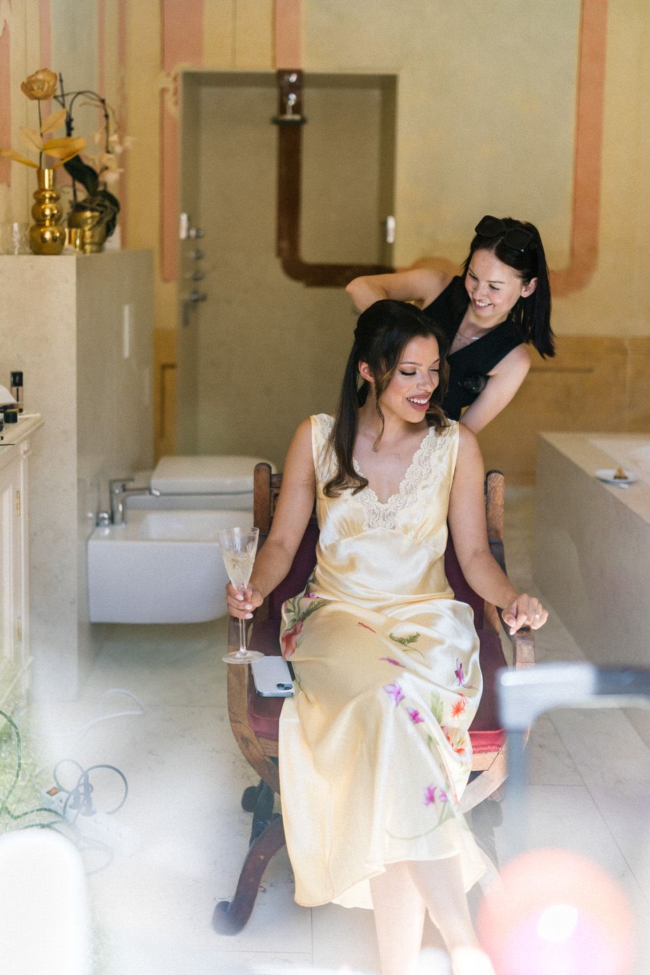 Getting ready scene in vintage bathroom with soft natural lighting.