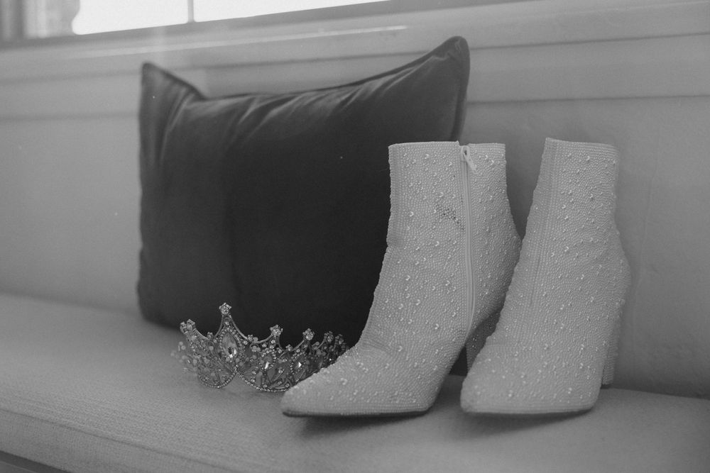 Delicate white bridal shoes displayed against a soft neutral background.