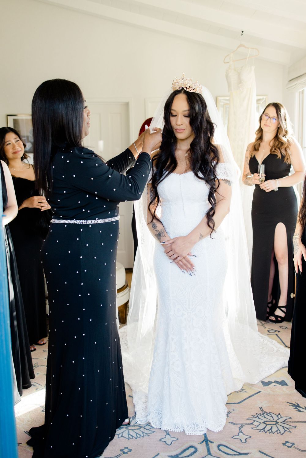 Wedding party members in black and white dresses sharing candid moments.