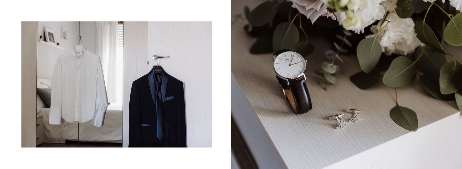 Groom's wedding details flat lay with white shirt, navy suit, watch, ring, and floral bouquet.