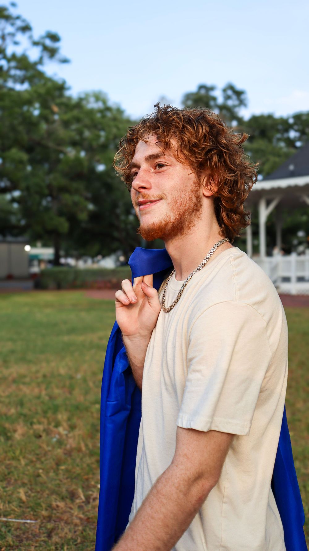 Person in casual attire posing outdoors against natural background.
