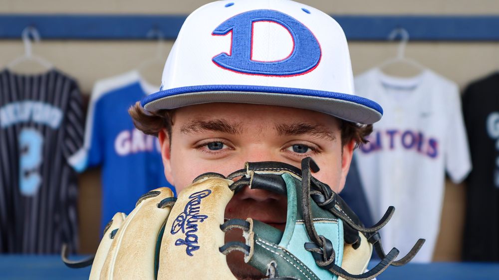 Baseball player wearing a blue and white cap in a close-up shot.