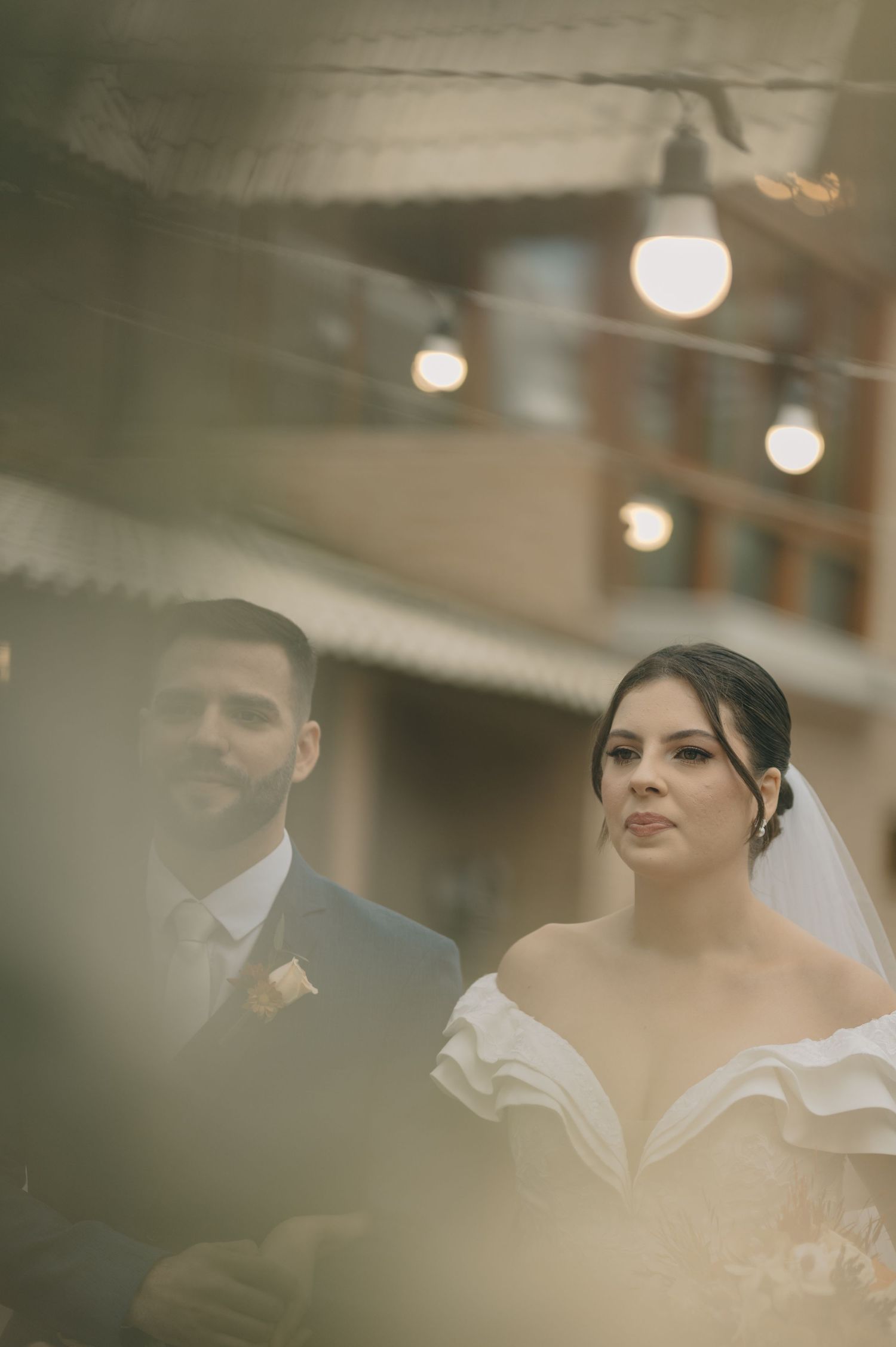 An intimate wedding portrait capturing a romantic moment under soft glowing lights.