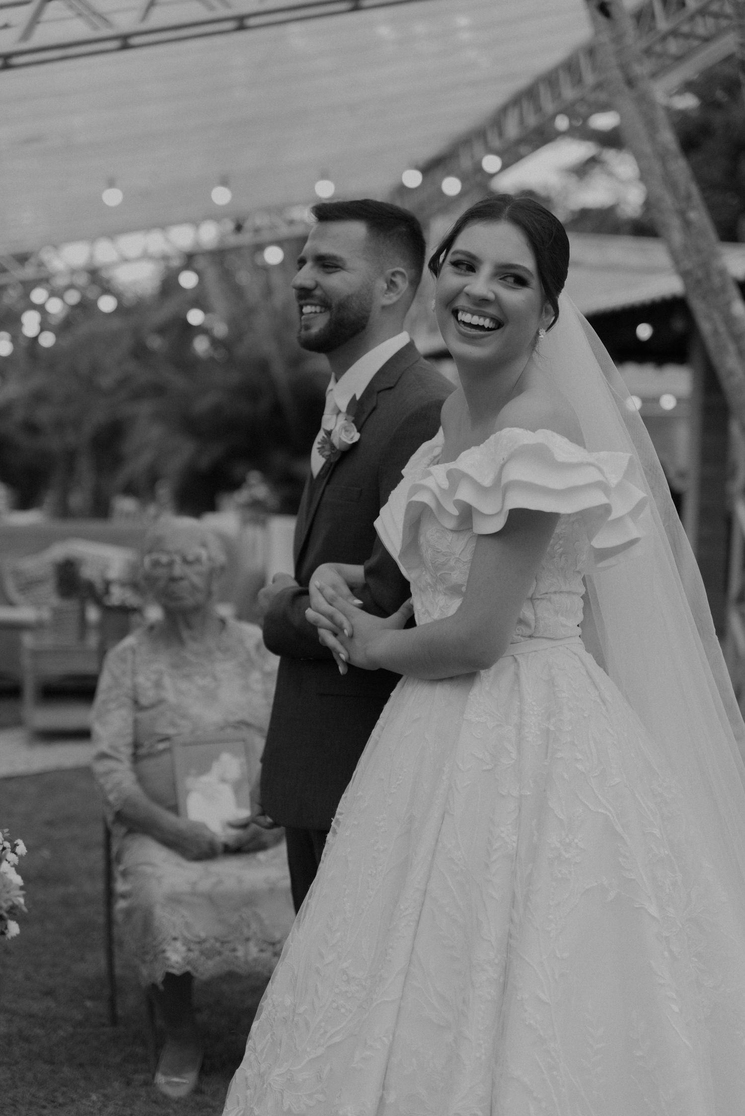 Wedding couple sharing a candid laugh together during their outdoor celebration.
