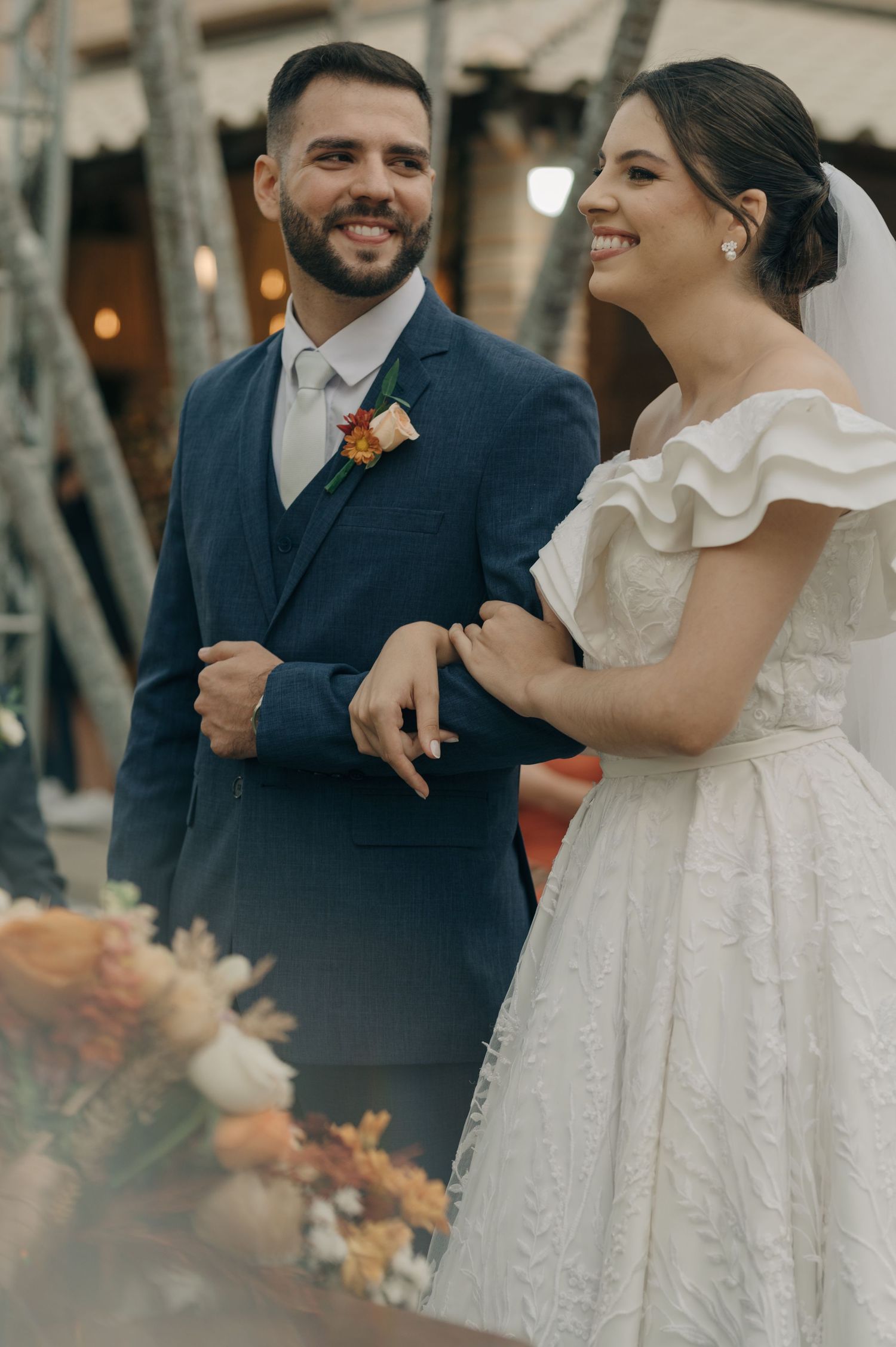 Candid moment of newlyweds smiling together at their garden wedding reception.