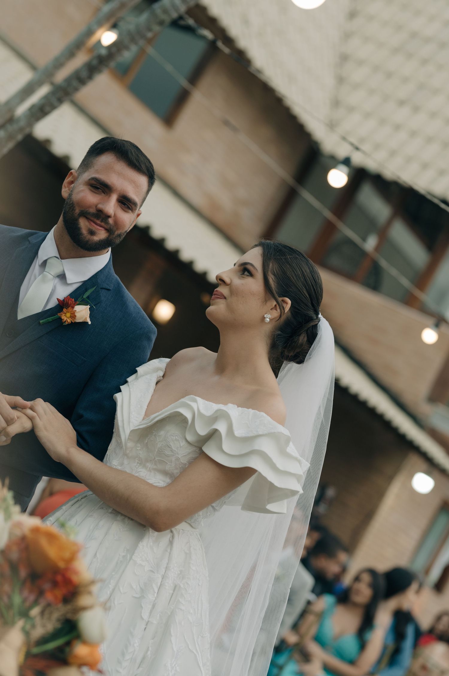Wedding couple dancing together during their outdoor celebration with string lights overhead.