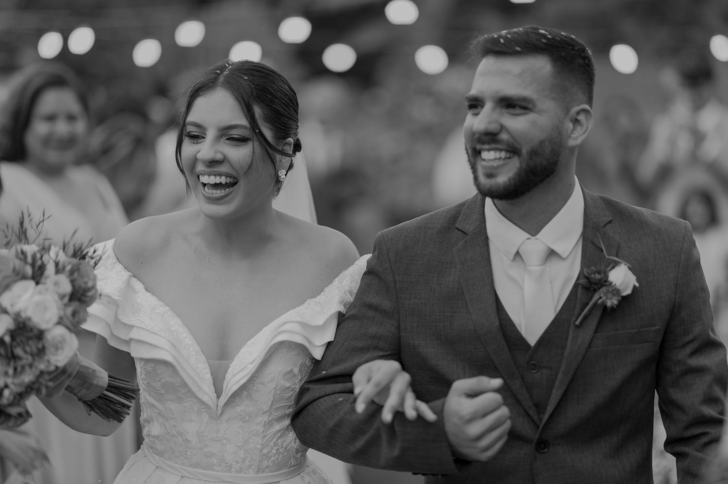 Black and white candid photo of newlyweds celebrating during their wedding ceremony.