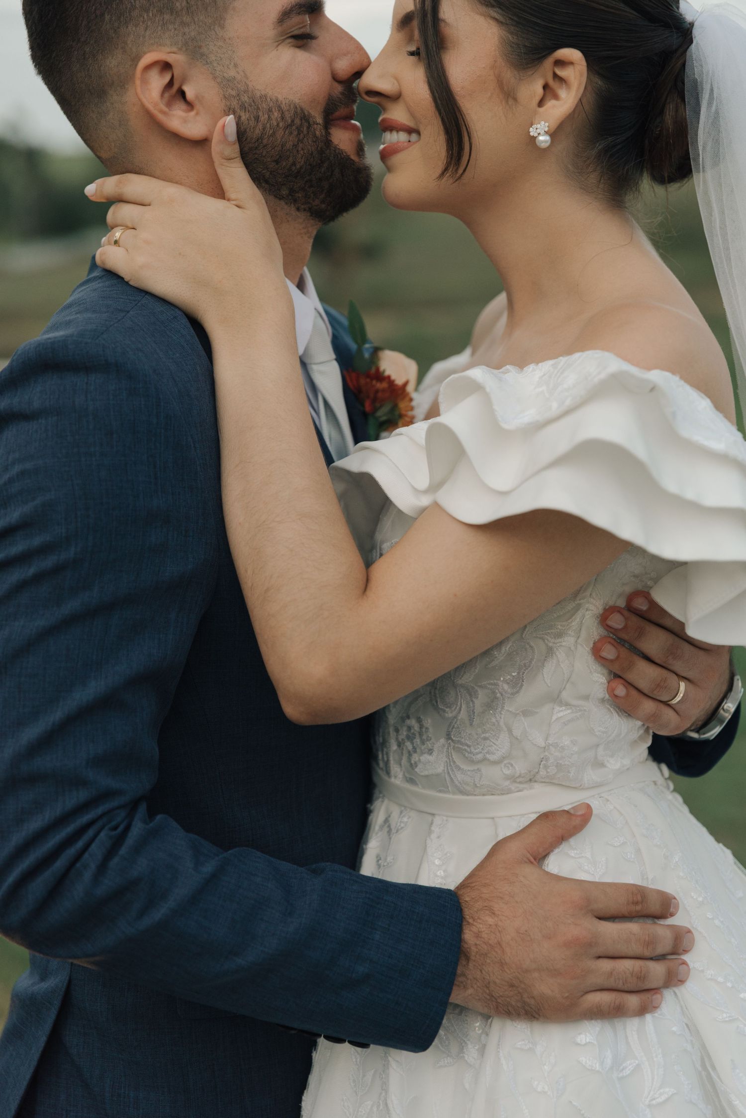 Intimate moment between newlyweds during outdoor wedding portrait session.