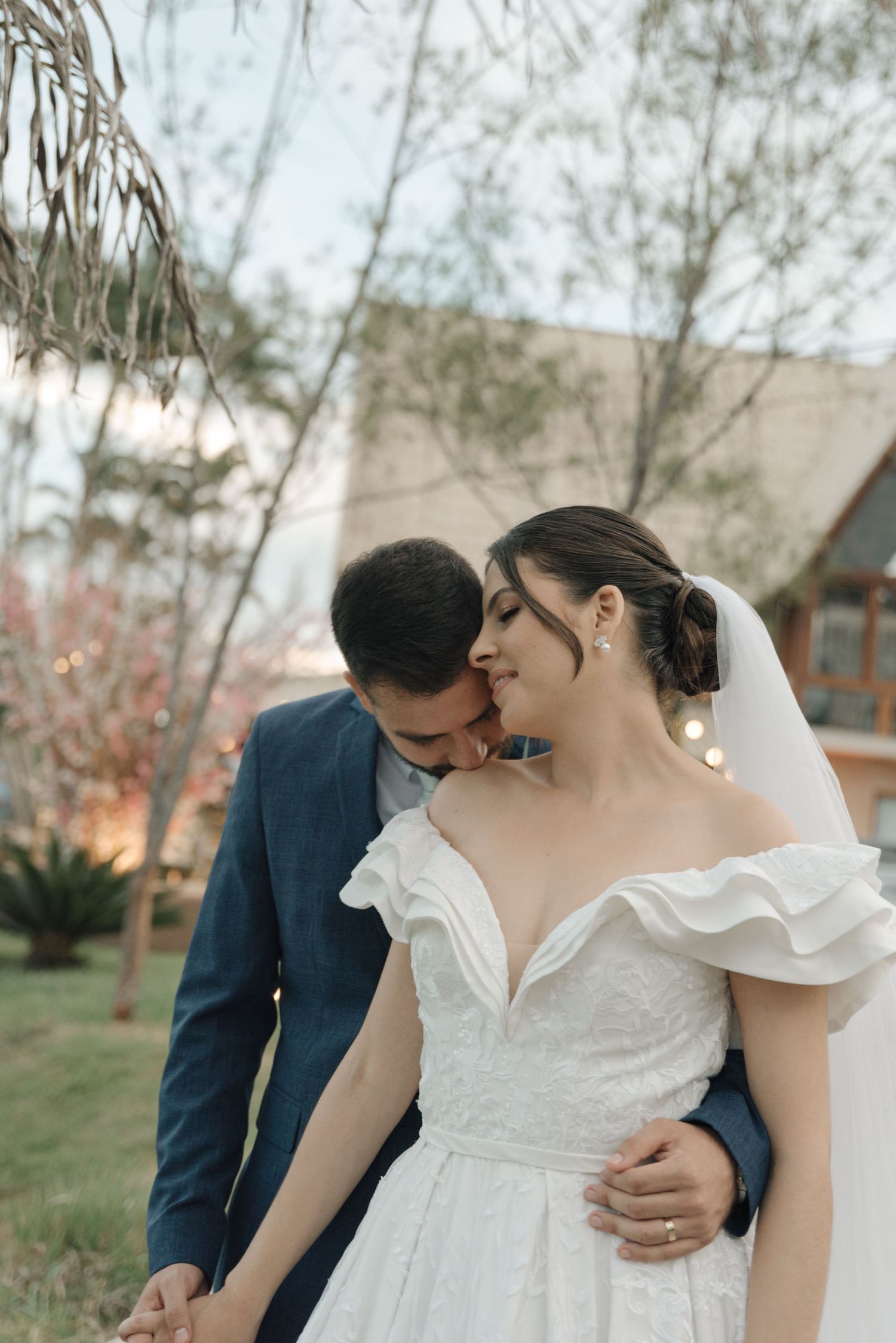 An intimate wedding moment captured outdoors with the couple sharing a tender embrace.