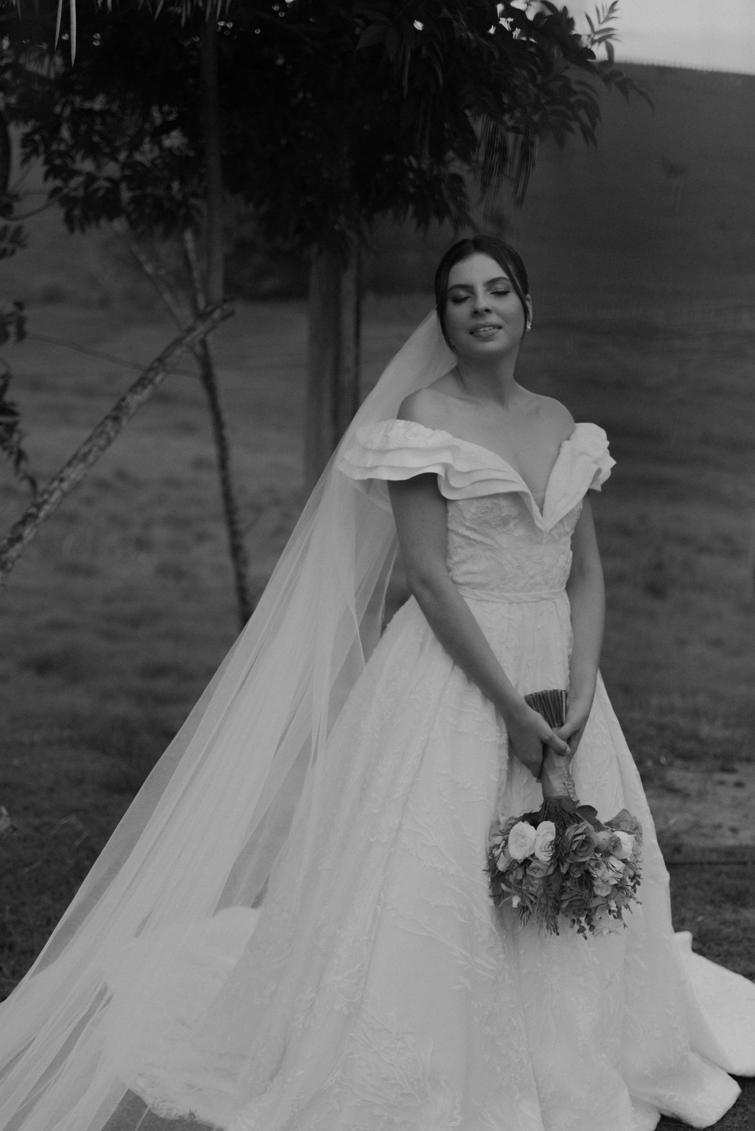 A classic black and white bridal portrait showcasing an elegant wedding dress with ruffled details.