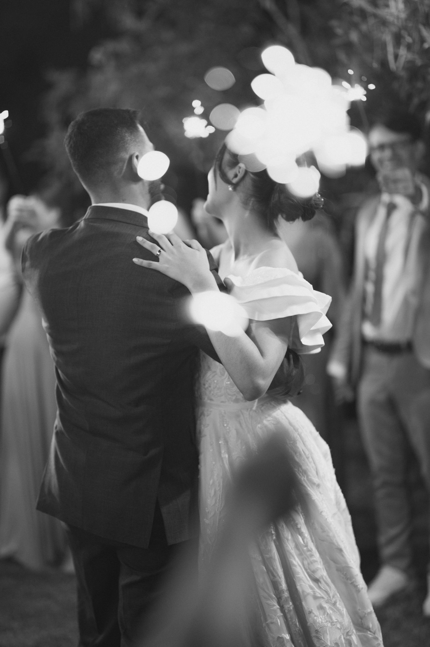 A dreamy black and white wedding photo with bokeh lights creating a magical atmosphere.