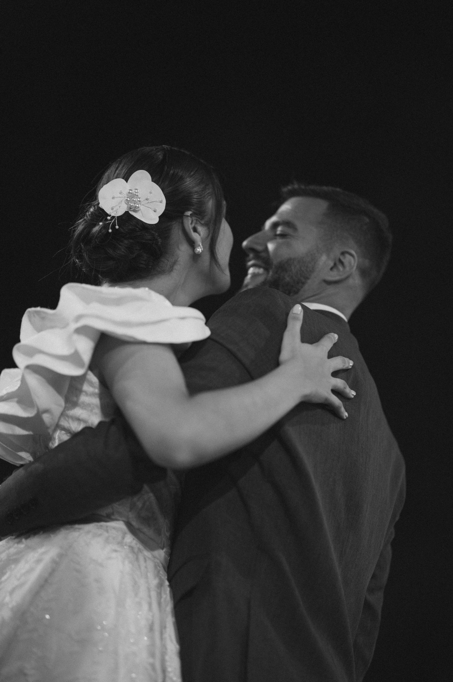 An emotional dance embrace between bride and groom captured in monochrome.
